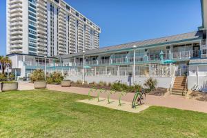 a building with a park in front of a building at Colorful Virginia Beach Studio - Steps to Beach! in Virginia Beach