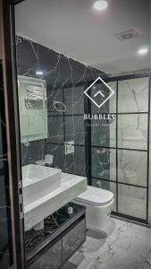 a bathroom with a toilet and a sink and a mirror at BUBBLES LUXURY CAMp in Wadi Rum
