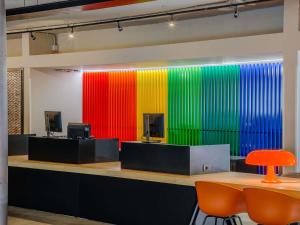 a brightly colored wall in an office with a table and chairs at Ibis Styles Roma Aurelia in Rome