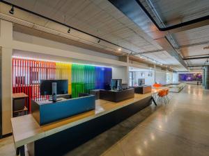 a lobby with colorful walls and desks and chairs at Ibis Styles Roma Aurelia in Rome