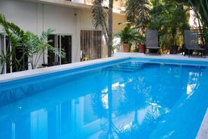 a swimming pool with blue water in front of a house at Patio Canarias Chacala Suites Pet-Friendly in Chacala