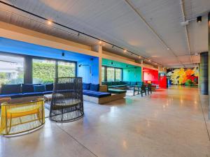 a large room with chairs and tables and blue walls at Ibis Styles Roma Aurelia in Rome