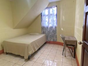 a small bedroom with a bed and a window at Casa Adelita in Huehuetenango