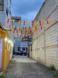 a alley with flags hanging from a brick wall at Casa Adelita in Huehuetenango