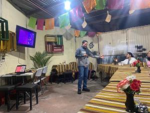 a man standing in a room in a room with tables at Casa Adelita in Huehuetenango