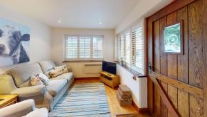 a living room with a couch and a wooden door at The Byre in Banbury