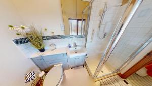 a bathroom with a toilet and a sink and a shower at The Byre in Banbury