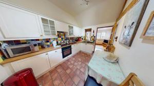 a kitchen with a table and a microwave at The Byre in Banbury