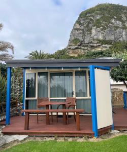 a cabin with a picnic table on a deck at Punakaiki Beach Hostel in Punakaiki