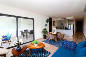 a living room with a blue couch and a table at Depa MAJUM Playa del Carmen in Playa del Carmen