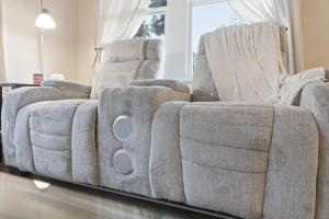 a couch sitting in a living room next to a window at Cozy 1BR Cottage w Kitchen & Laundry in Lafayette