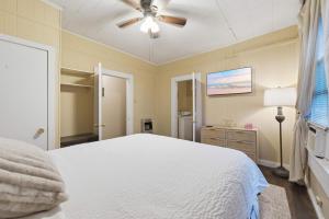 a bedroom with a white bed and a ceiling fan at Cozy 1BR Cottage w Kitchen & Laundry in Lafayette