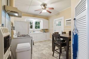 a kitchen with a table and a ceiling fan at Cozy 1BR Cottage w Kitchen & Laundry in Lafayette