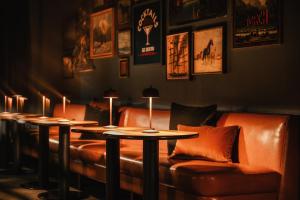 a row of tables and leather couches in a room at Dexter Hotel in Elk Rapids