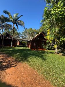a house with a palm tree in front of a yard at Las Cabañas in Santo Tomé