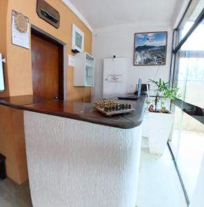 a kitchen with a counter top in a room at Zaya Mar Pousada in Bertioga