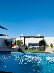 a swimming pool with chairs and a table and a swing at شاليهات الشهد والحلا in Amman +8 photos