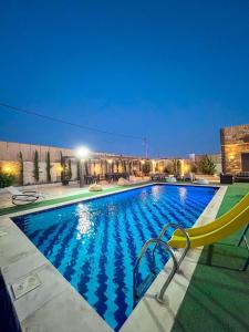 a large swimming pool with a yellow chair next to it at شاليهات الشهد والحلا in Amman