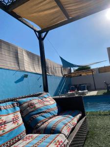 a couch sitting under a tent next to a pool at شاليهات الشهد والحلا in Amman