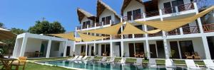 a hotel with a swimming pool in front of a building at Hali, El Paredón in Sipacate