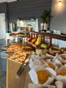 a buffet line with various types of bread and pastries at Colonial Palms Motor Inn in Airlie Beach