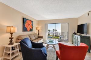 a living room with a couch and chairs and a table at Caprice Resort by Travel Resort Services in St. Pete Beach