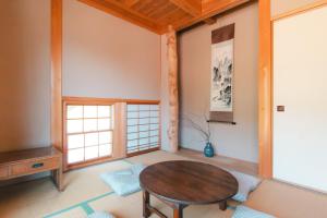a living room with a wooden table and a window at Nakasendo Shiki - Private Garden Villa in Nagiso
