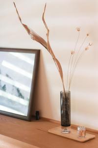 a vase with branches in it sitting on a table at Nakasendo Shiki - Private Garden Villa in Nagiso +30 photos