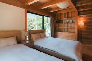 a bedroom with two beds and a window at Nakasendo Shiki - Private Garden Villa in Nagiso