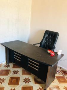 a black office desk with a black leather chair at Maria Apartment in Alexandria +2 photos