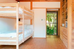 a room with two bunk beds and a doorway at Nakasendo Shiki - Private Garden Villa in Nagiso
