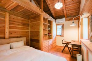 a bedroom with wooden walls and a bed and a desk at Nakasendo Shiki - Private Garden Villa in Nagiso