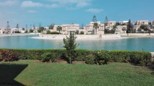 a large body of water with houses in the background at Virginia beach village in El Alamein