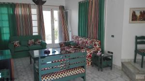 a living room with a couch and a table and a chair at Virginia beach village in El Alamein