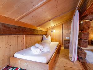 a bed in a wooden cabin with towels at Dorf30 in Going am Wilden Kaiser