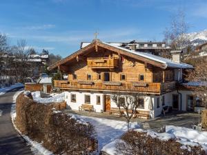 a large wooden house with snow on the ground at Dorf30 in Going am Wilden Kaiser