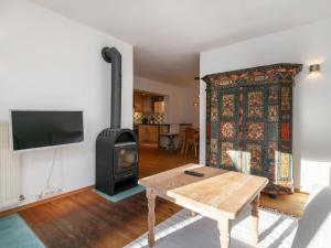 a living room with a wood stove and a table at Dorf30 in Going am Wilden Kaiser