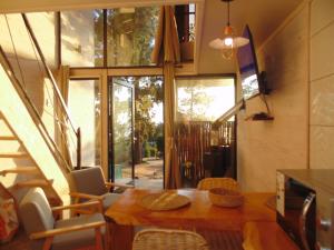 a dining room with a table and a large window at Lodge Terra Mar in Pichilemu