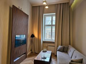 a living room with a couch and a table and a window at Vision Luxury Apartment Rynek in Wrocław