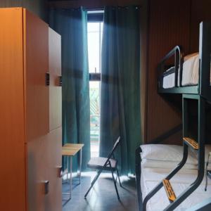 a bedroom with a bunk bed and a chair and a window at Sanibelle Hotel in Coron