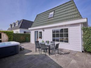 a patio with a table and chairs and a tub at t Kaatsheuveltje 1 in Kaatsheuvel