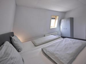 a bedroom with two beds and a window at t Kaatsheuveltje 1 in Kaatsheuvel