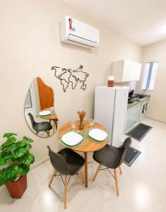 a kitchen with a table and chairs and a refrigerator at Maria Lofts in Itaguaí