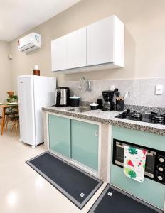 a kitchen with white cabinets and a counter top at Maria Lofts in Itaguaí