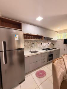 a kitchen with a stainless steel refrigerator and a sink at Season Ilhéus in Ilhéus