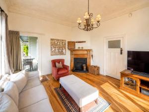 a living room with a couch and a tv at Crescent Villa - Stay Waiheke in Ostend