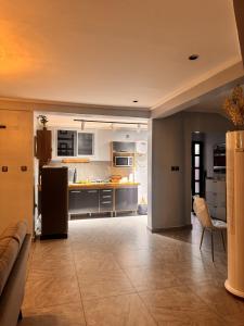 a large kitchen with a counter and a table at Le Cocon de Jade - Nylon Bastos in Yaoundé