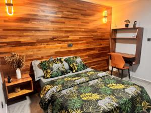 a bedroom with a bed and a wooden wall at Le Cocon de Jade - Nylon Bastos in Yaoundé