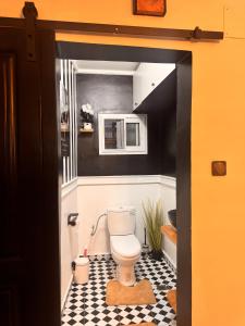 a bathroom with a toilet and a checkered floor at Le Cocon de Jade - Nylon Bastos in Yaoundé