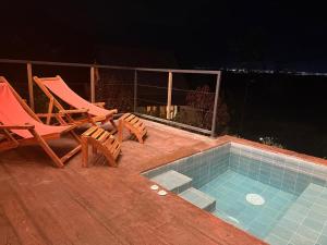 een zwembad met twee stoelen, een tafel en een toezichthouder bij Macana Eco Hotel in Montenegro